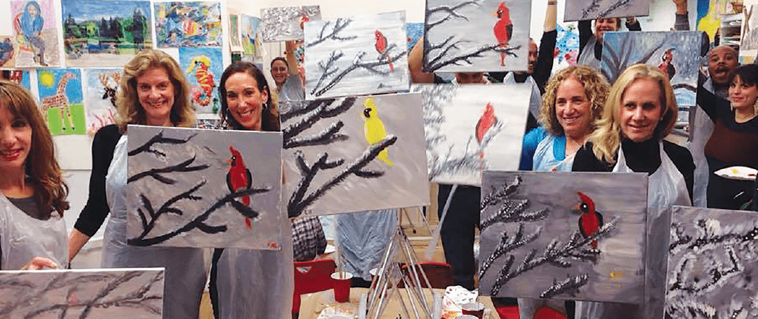 adults showing off their paint and sip artworks