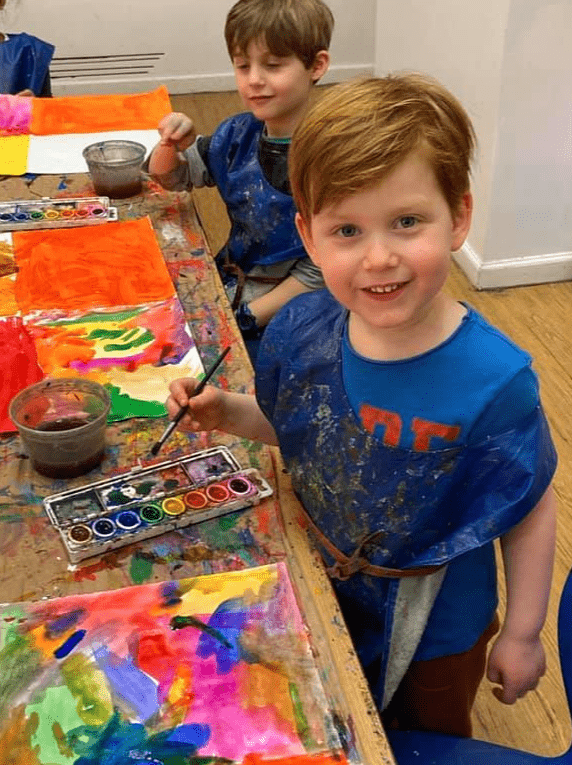 smiles and watercolor artwork at kids at art