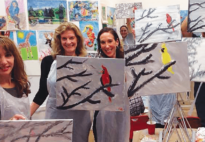 adults showing off their paint and sip masterpieces